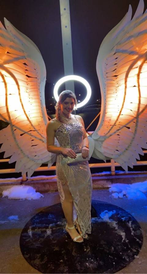 Hailey standing under angel wings and halo